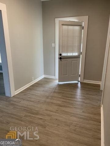 foyer entrance featuring baseboards and wood finished floors