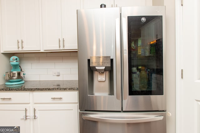 3495 Delegate Aly, Scottdale, GA 30079 - details with stainless steel refrigerator with ice dispenser, dark stone counters, backsplash, and white cabinetry