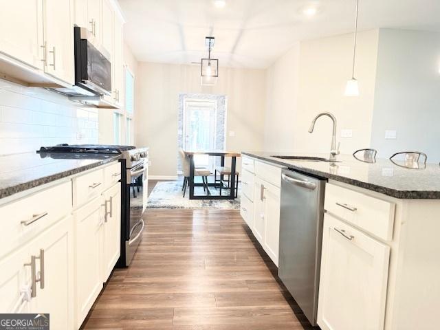 3495 Delegate Aly, Scottdale, GA 30079 - kitchen featuring dark stone counters, appliances with stainless steel finishes, wood finished floors, and a sink