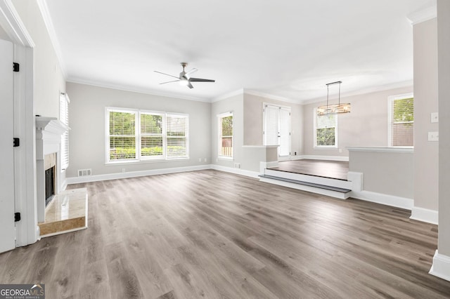 unfurnished living room featuring wood finished floors, visible vents, a ceiling fan, and baseboards
