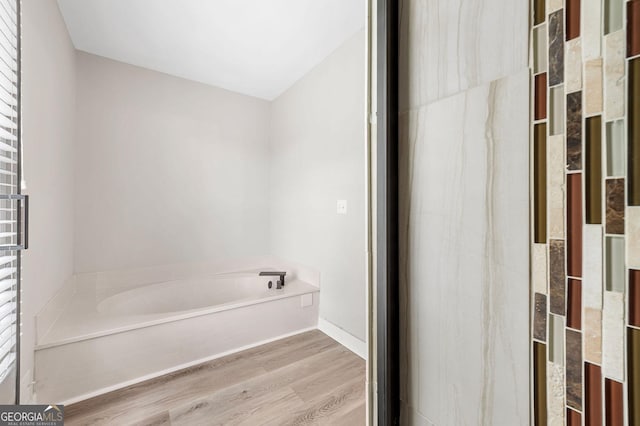 bathroom featuring a bath and wood finished floors