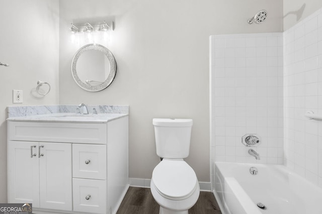 bathroom featuring toilet, vanity, wood finished floors, and baseboards