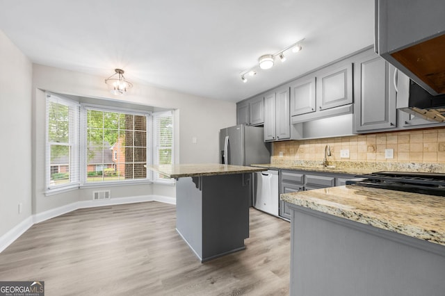 kitchen with gray cabinets, stainless steel dishwasher, and a sink