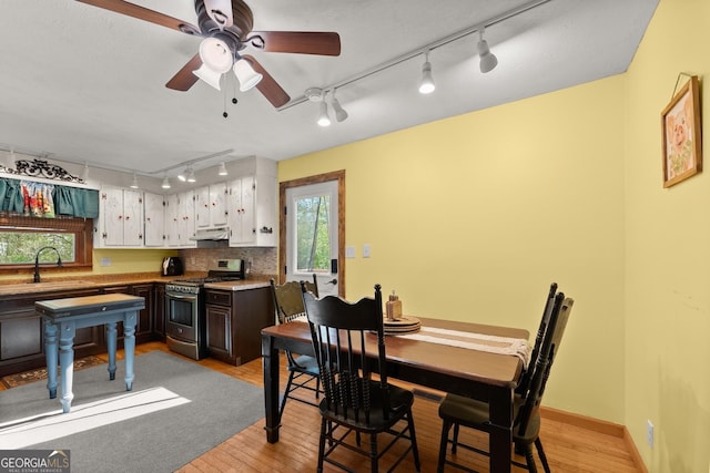 dining space with light wood-style flooring, baseboards, and a ceiling fan