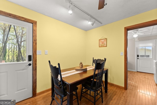 dining space featuring light wood-style flooring, baseboards, and a ceiling fan