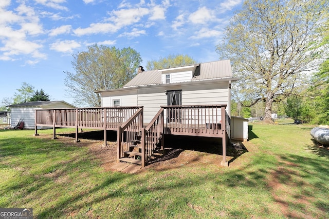 rear view of house featuring a yard, metal roof, a deck, and a chimney
