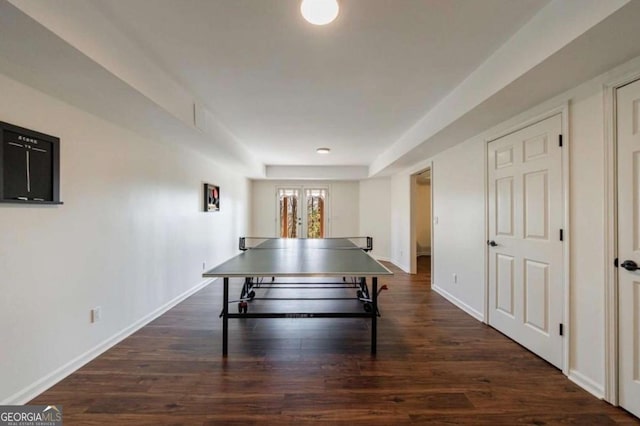 recreation room featuring baseboards and dark wood finished floors