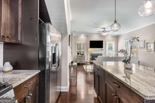 kitchen featuring stainless steel fridge, a ceiling fan, dark wood finished floors, a fireplace, and pendant lighting