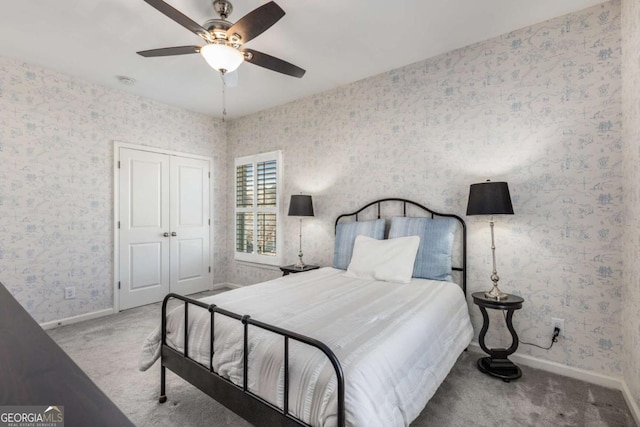 carpeted bedroom with a ceiling fan, wallpapered walls, baseboards, and a closet