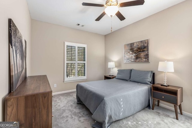 carpeted bedroom with visible vents, baseboards, and a ceiling fan