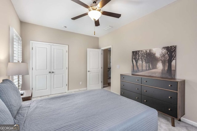 bedroom with a closet, baseboards, visible vents, a ceiling fan, and light colored carpet