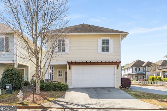 view of front of home with concrete driveway, a garage, and fence