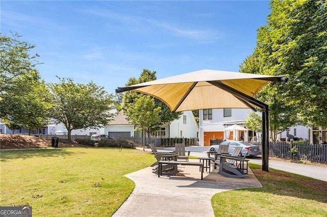 view of community featuring a patio, a yard, and fence