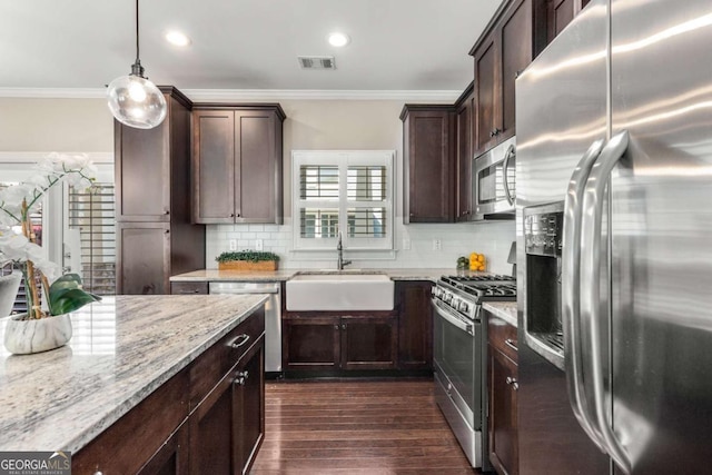 kitchen featuring a sink, ornamental molding, stainless steel appliances, dark wood-type flooring, and decorative backsplash