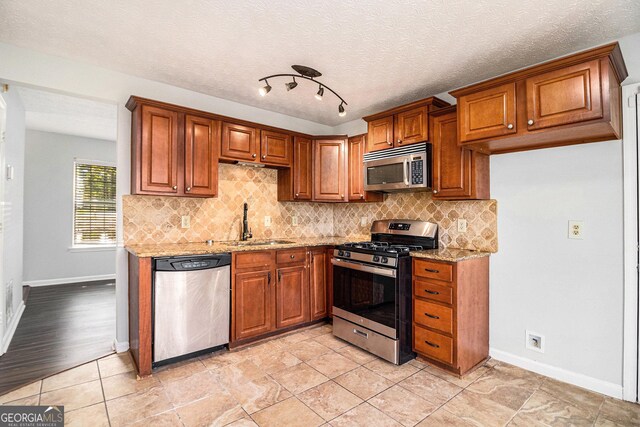 3742 Linecrest Rd, Ellenwood, GA 30294 - kitchen featuring brown cabinets, a sink, backsplash, and appliances with stainless steel finishes