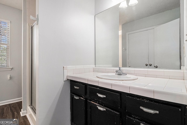 3742 Linecrest Rd, Ellenwood, GA 30294 - bathroom featuring a stall shower, wood finished floors, vanity, and baseboards