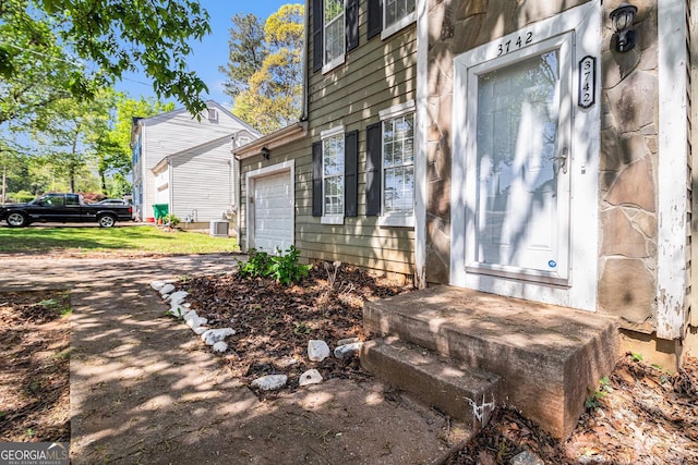 3742 Linecrest Rd, Ellenwood, GA 30294 - entrance to property with central air condition unit, driveway, and a garage