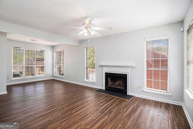 3742 Linecrest Rd, Ellenwood, GA 30294 - unfurnished living room featuring dark wood-type flooring, a fireplace with flush hearth, baseboards, and a ceiling fan
