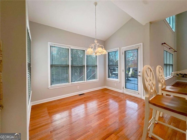 3195 Vickery Dr NE, Marietta, GA 30066 - dining area with a notable chandelier, baseboards, vaulted ceiling, light wood-style flooring, and visible vents