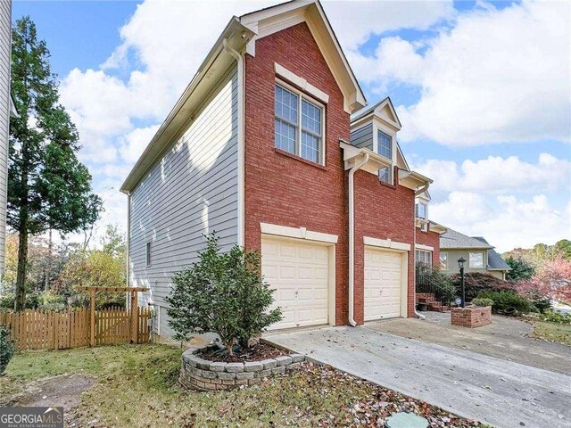 3195 Vickery Dr NE, Marietta, GA 30066 - view of side of home featuring brick siding, fence, a garage, and driveway
