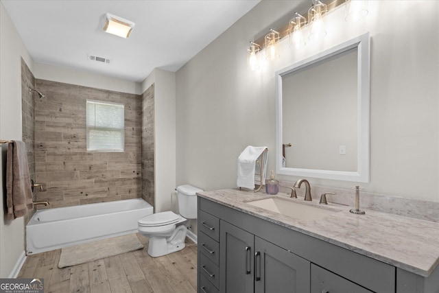 full bathroom with toilet, visible vents, vanity, wood finished floors, and shower / bathing tub combination