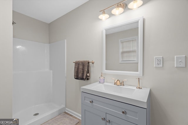 bathroom featuring a shower and vanity