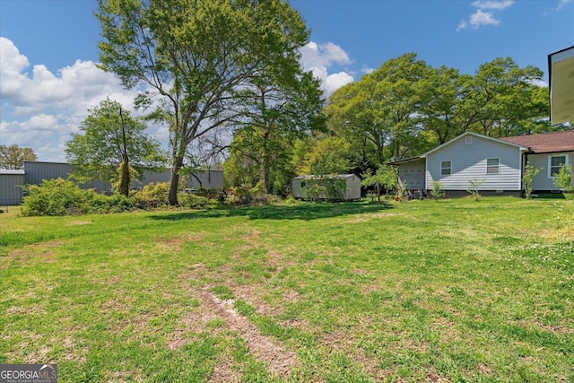 view of yard featuring an outbuilding and a shed