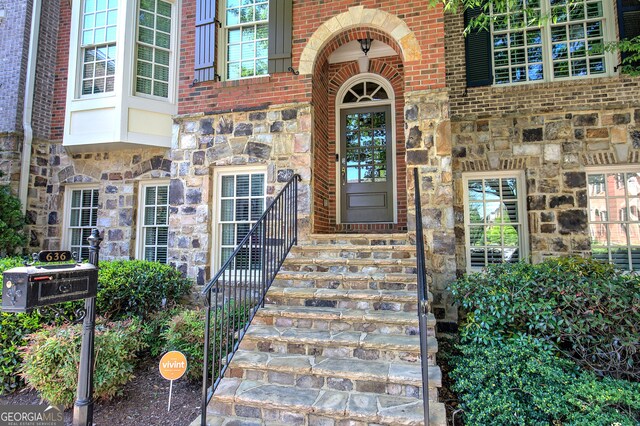 entrance to property with brick siding and stone siding