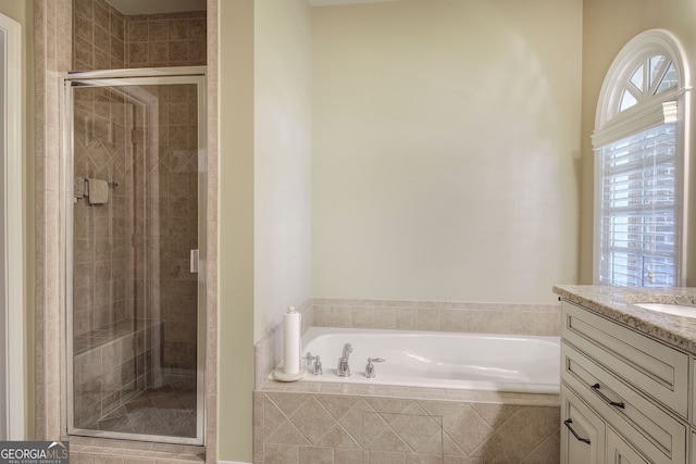 bathroom with a bath, a stall shower, and vanity