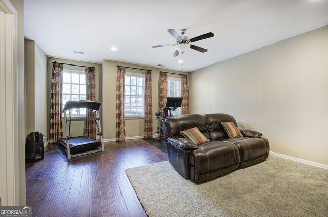 living area with dark wood-style floors, baseboards, visible vents, and ceiling fan