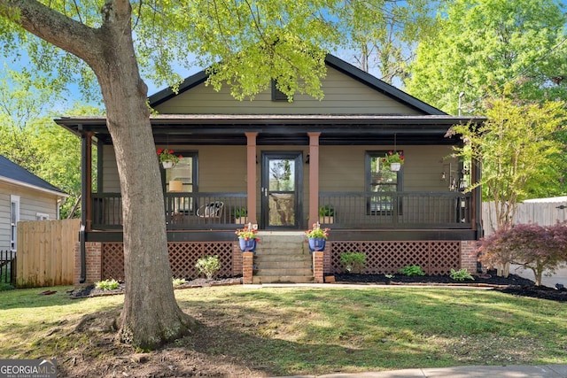 bungalow featuring a front yard, a porch, and fence