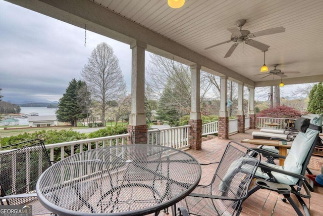 view of patio / terrace featuring outdoor dining space, ceiling fan, and a water view