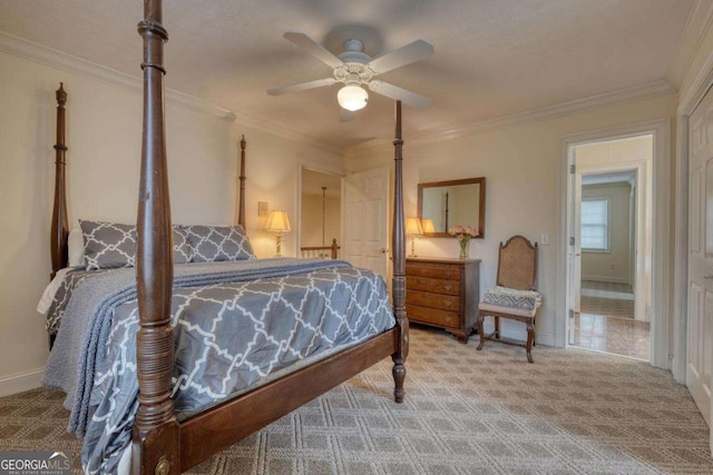 carpeted bedroom featuring ornamental molding, a ceiling fan, and baseboards