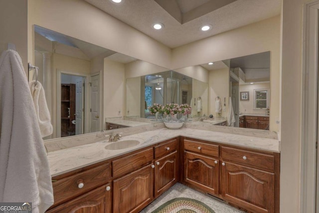 bathroom with recessed lighting, vanity, and a shower