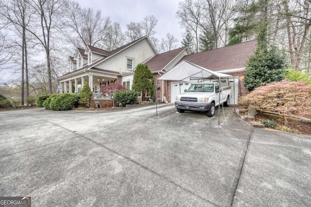 view of front of property with concrete driveway, an attached garage, and covered porch