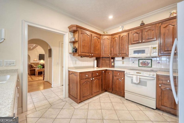 kitchen featuring white appliances, arched walkways, light countertops, decorative backsplash, and crown molding