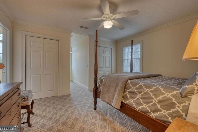 bedroom with crown molding, light colored carpet, and a ceiling fan