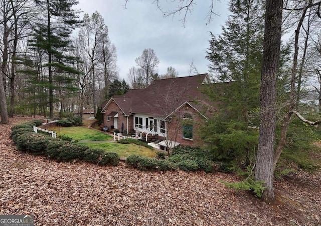view of front of home with brick siding and a patio area