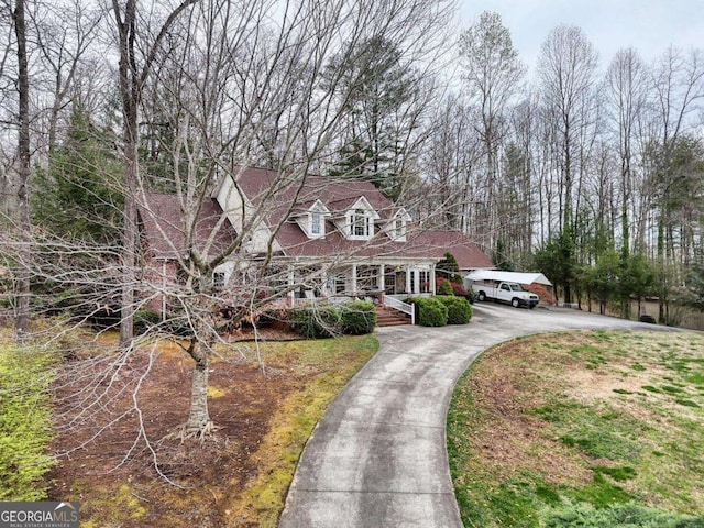 cape cod-style house featuring driveway and a porch