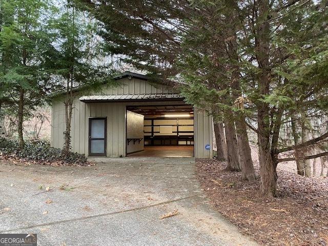 view of outdoor structure with concrete driveway and an outbuilding