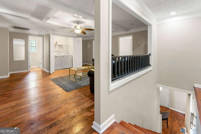 living room with ornamental molding, independent washer and dryer, wood finished floors, a ceiling fan, and baseboards