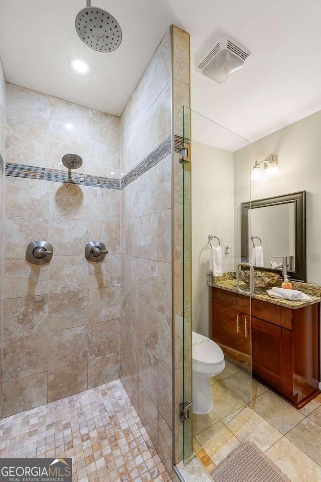 bathroom featuring a stall shower, vanity, and toilet