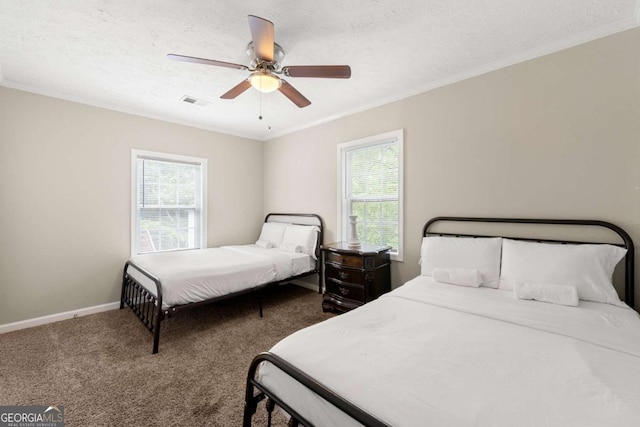 carpeted bedroom featuring baseboards, ornamental molding, ceiling fan, and a textured ceiling