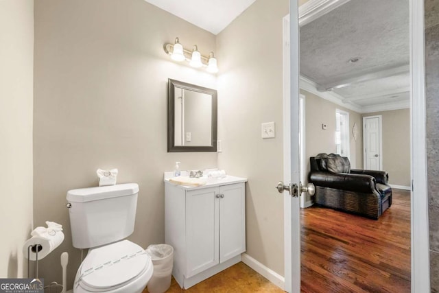 half bath featuring ornamental molding, toilet, baseboards, vanity, and wood finished floors