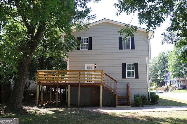 rear view of property featuring stairway and a deck