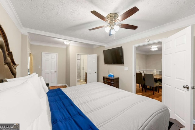bedroom featuring a textured ceiling, crown molding, wood finished floors, a ceiling fan, and ensuite bath