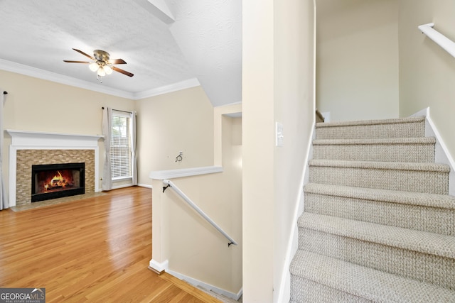 5213 Pinnacle Point Cts, Norcross, GA 30071 - staircase with ornamental molding, a textured ceiling, a fireplace with flush hearth, ceiling fan, and wood finished floors