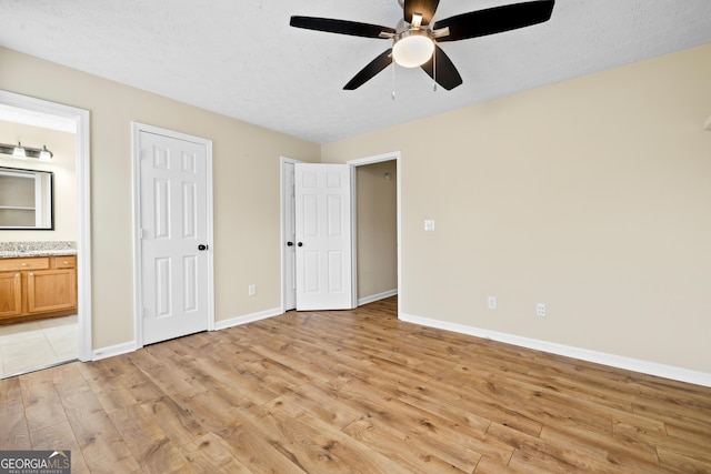 5213 Pinnacle Point Cts, Norcross, GA 30071 - unfurnished bedroom featuring baseboards, a textured ceiling, connected bathroom, ceiling fan, and light wood finished floors