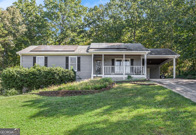 ranch-style home featuring a carport, covered porch, driveway, and a front lawn