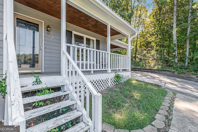 view of exterior entry featuring covered porch